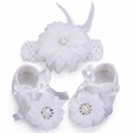 white infant booties and matching hair accessories